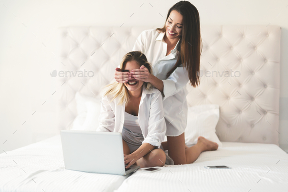 Two beautiful young girls having fun on bed Stock Photo by nd3000